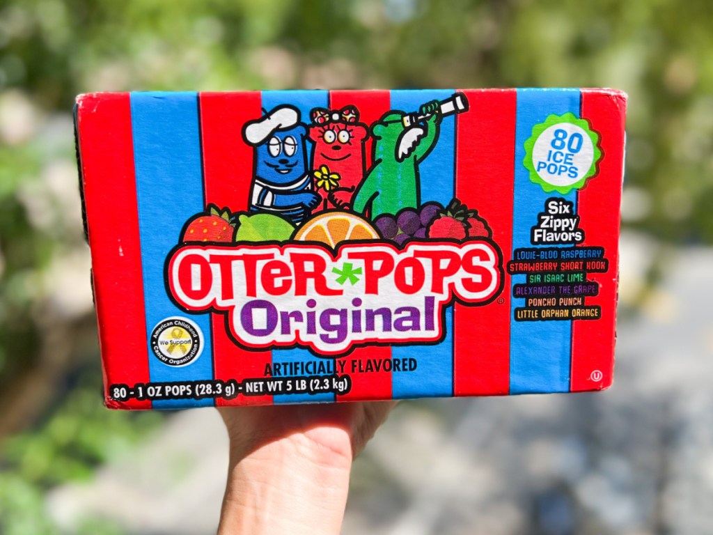 person holding up box of otter pops outside
