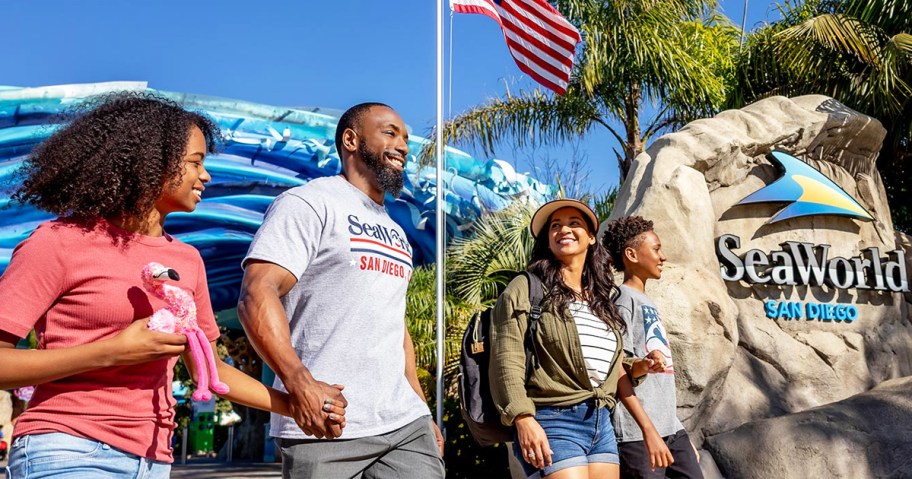family walking next to seaworld san diego sign