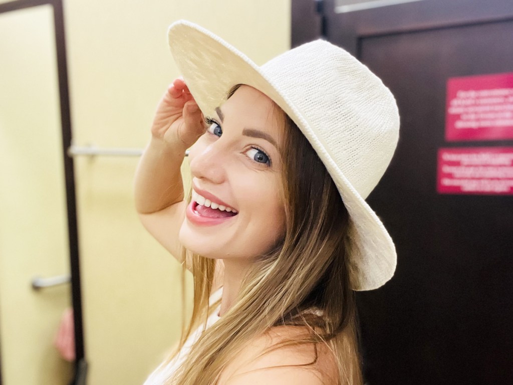 woman trying on a white hat