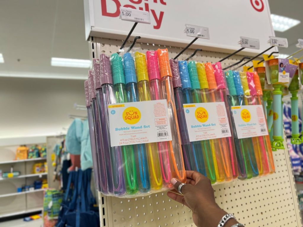 Hand grabbing a pack of bubble wands at Target