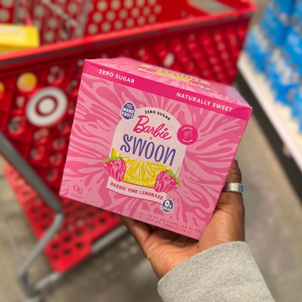 Swoon Lemonade Barbie Pink Lemonade in woman's hand with Target grocery cart in background