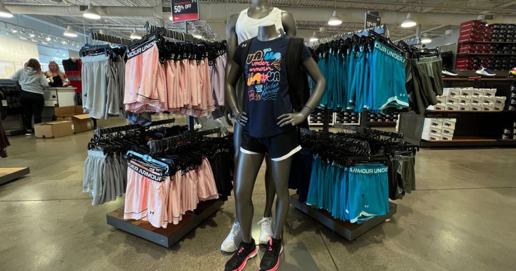Child and Adult Size Mannequins in front of racks of Under Armour Shorts