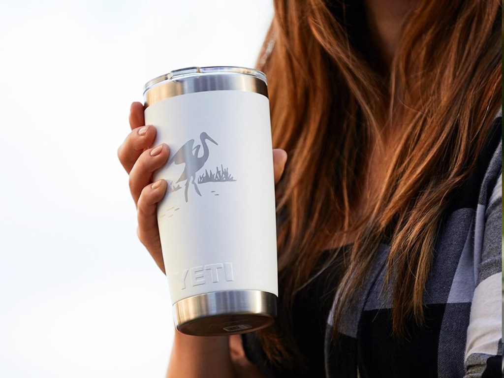 woman holding white yeti tumbler with custom design on it