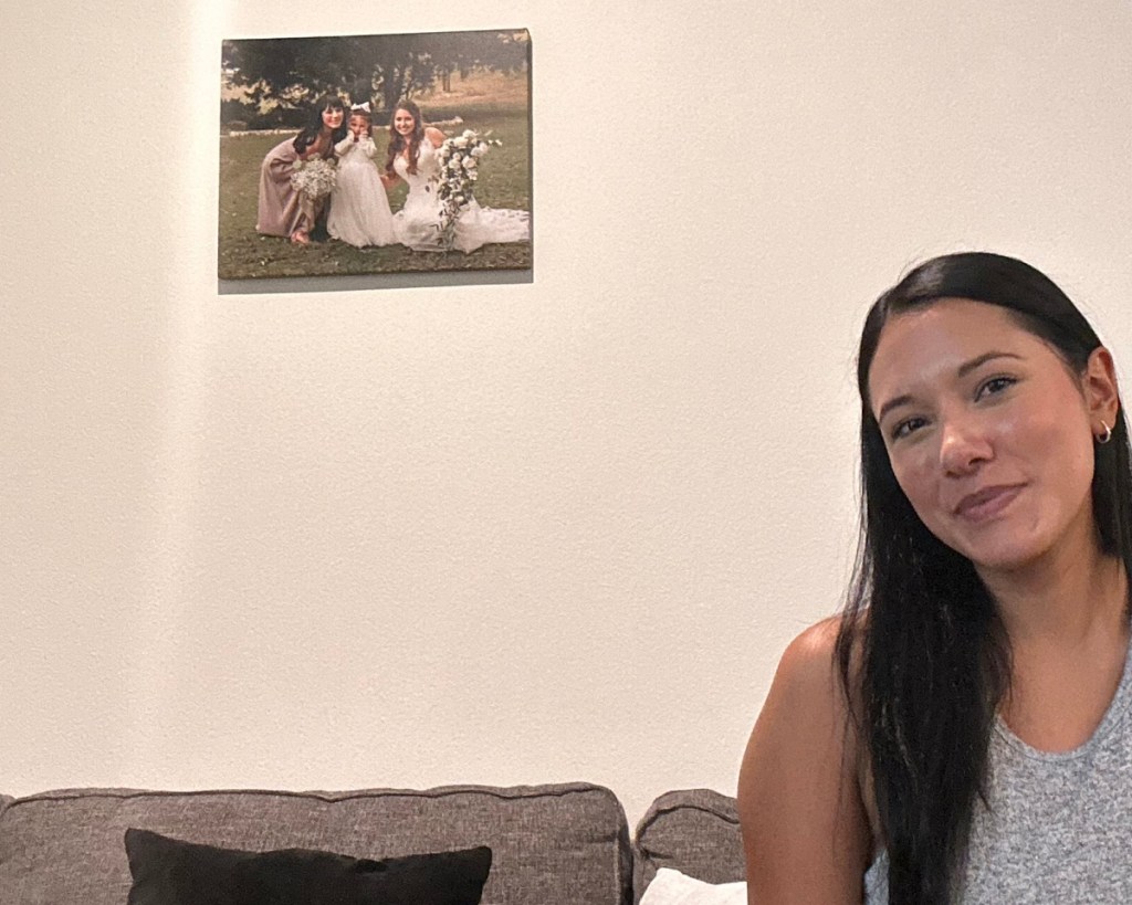 woman sitting near wall with photo canvas