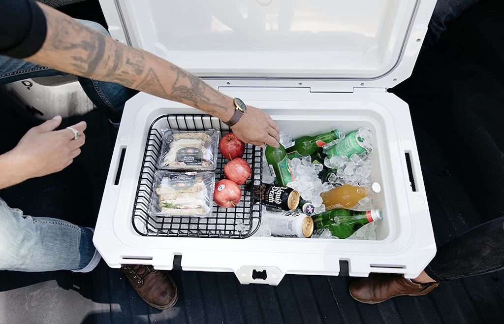 Igloo cooler open with ice and drinks and apples