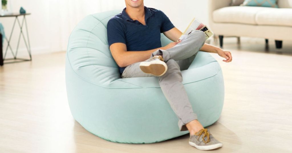 man sitting in blue beanless bag chair