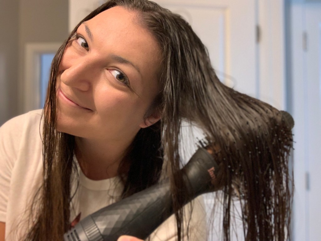 smiling woman with wet hair using the lange dryer brush