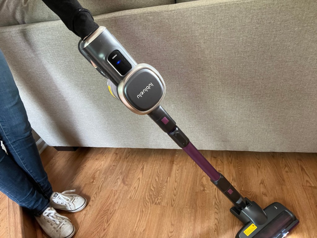woman cleaning with cordless stick vacuum 