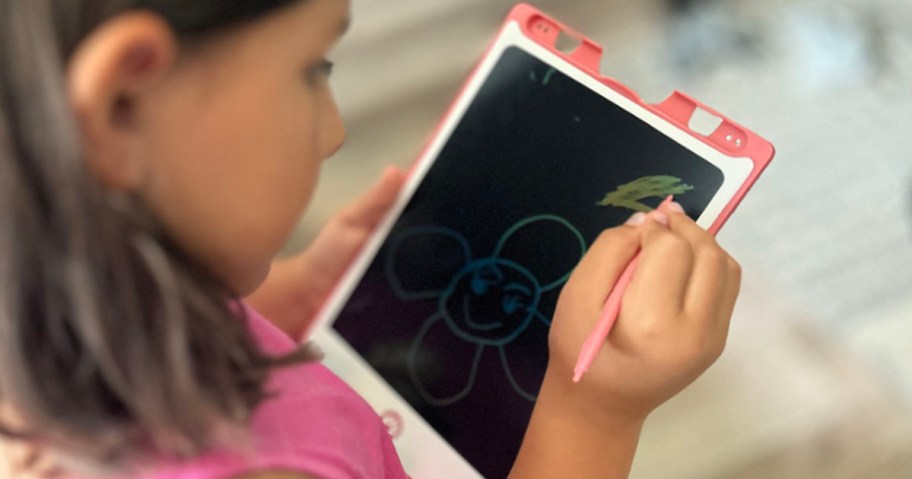 child drawing on pink magic doodle board