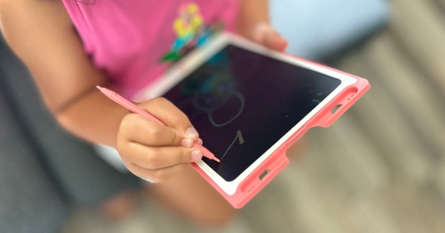 child drawing on pink magic doodle board