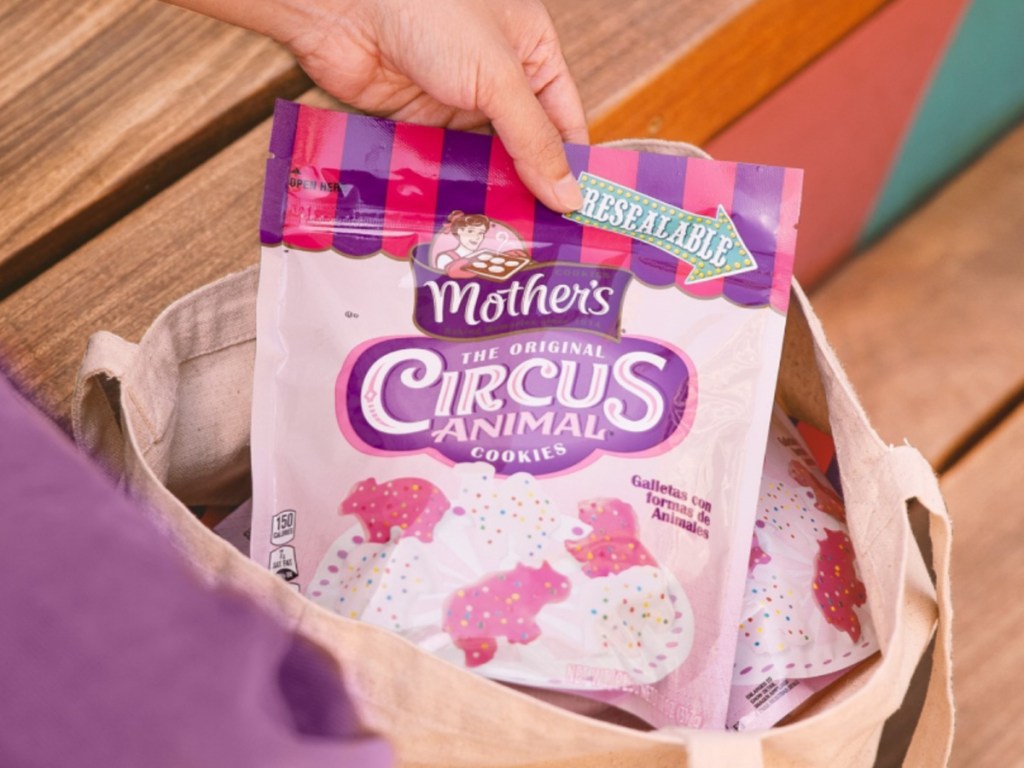 woman pulling a bag of mother's circus animal cookies out of a tote bag