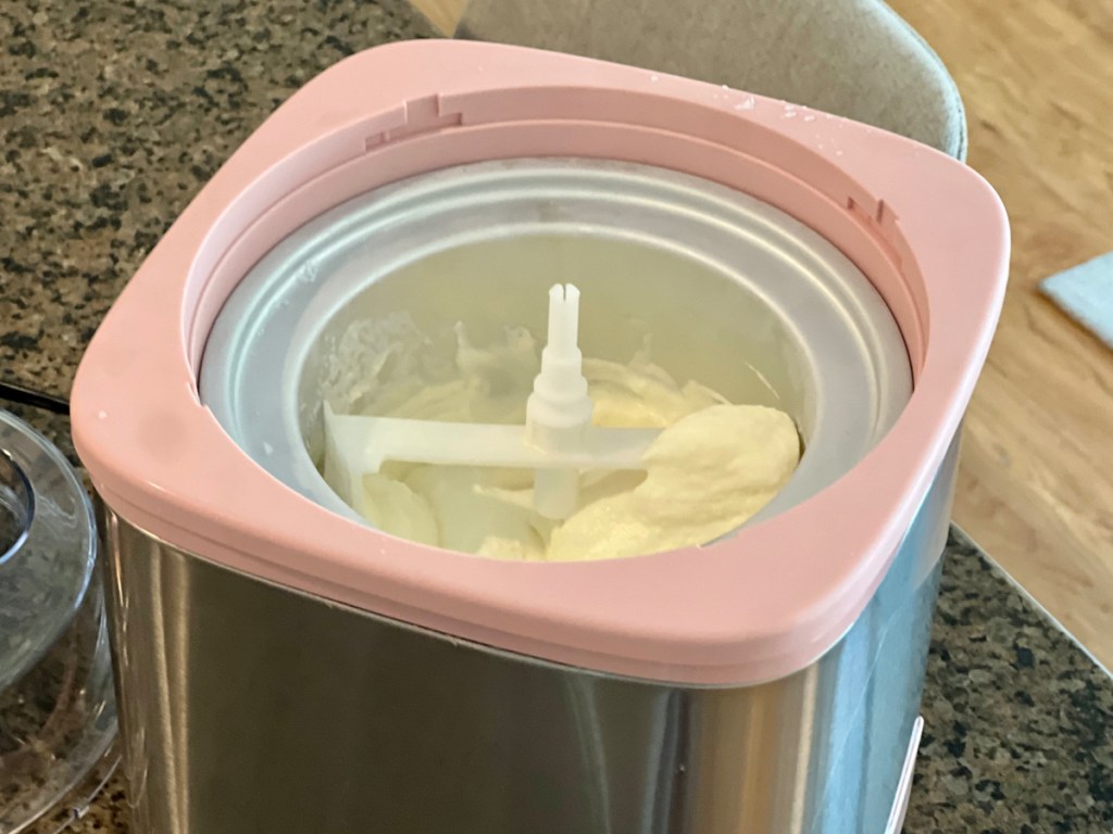 pink ice cream maker with ice cream inside of it