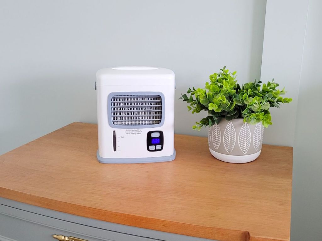 portable mini air cooler on table near plant