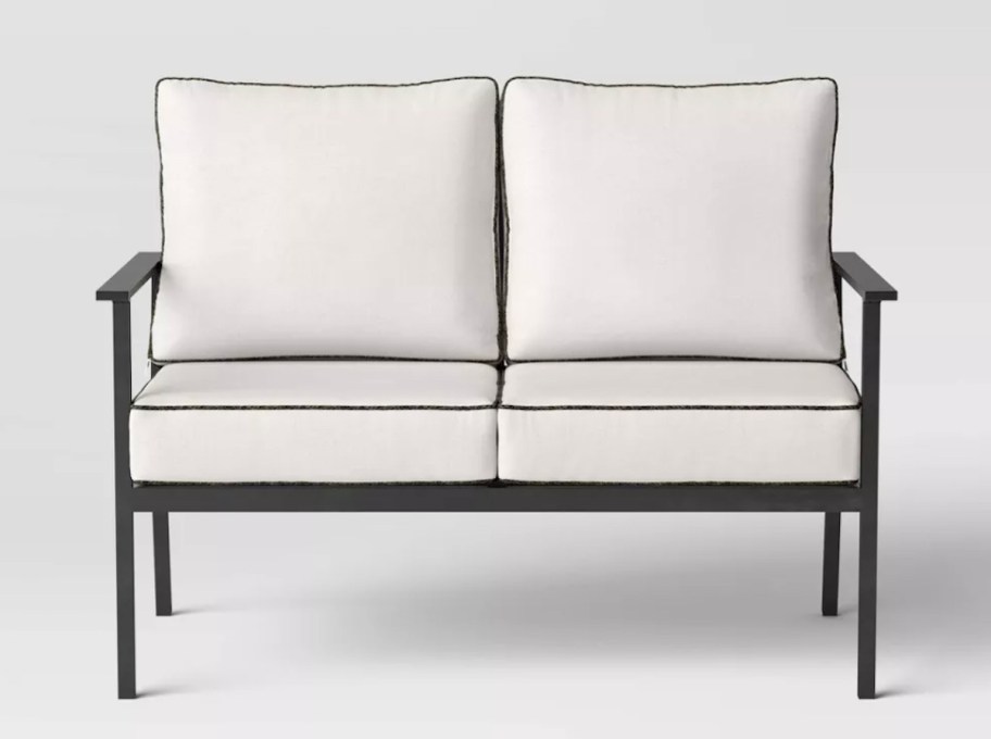 stock photo of black iron and white cushioned love seat patio sofa