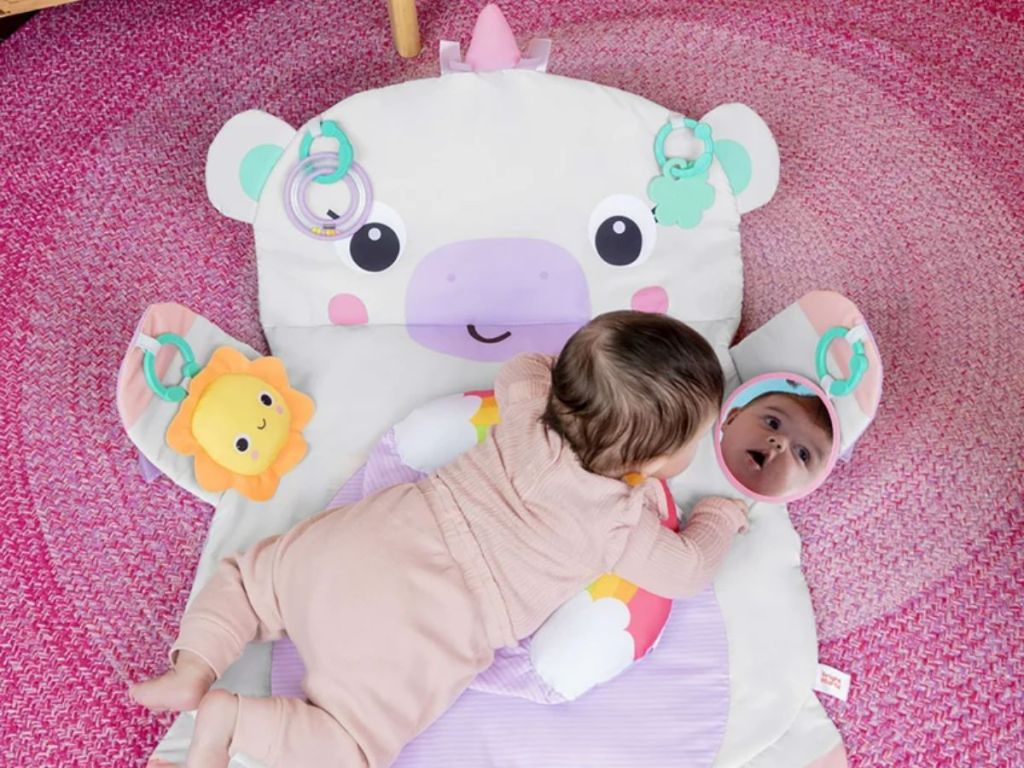 Bright Starts Unicorn Tummy Time Prop & Play Baby Activity Mat shown with baby playing on it 