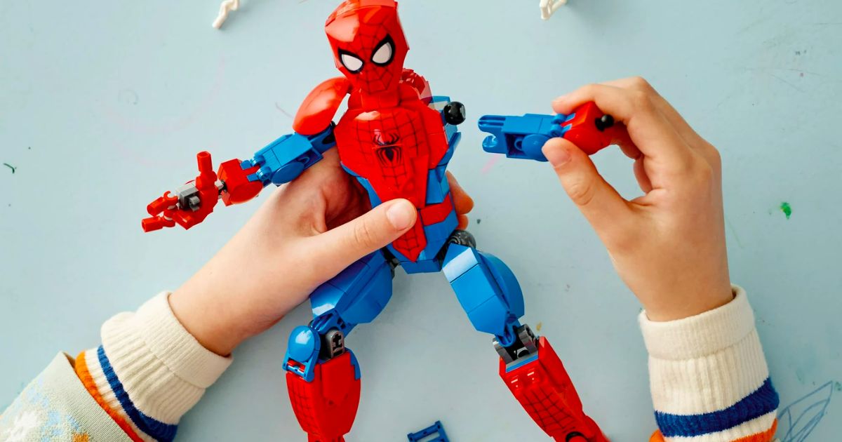 a kids hands holding a LEGO Marvel Spider-Man action figure.