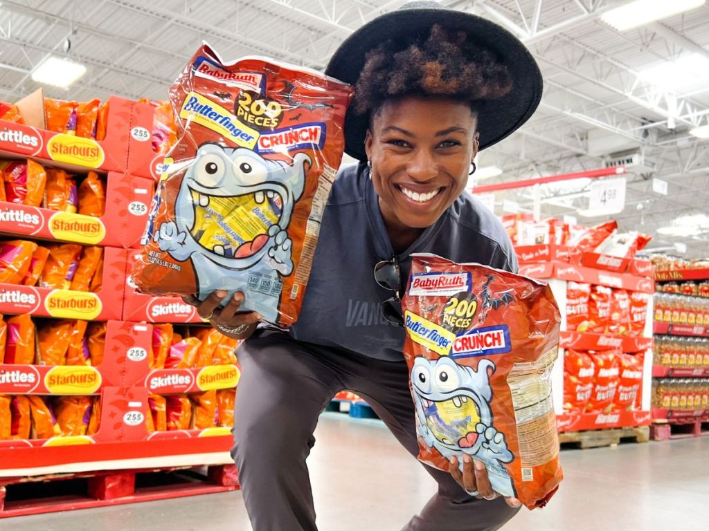 Cam holding giant bags of Halloween candy at Sam's Club