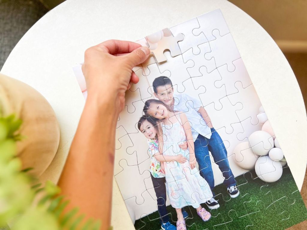 Walgreens Photo Puzzle shown with a pic of kids and a woman's hand putting a puzzle piece in
