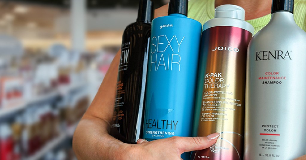 person holding large bottles of Sexy Hair, Kenra and Joico hair care