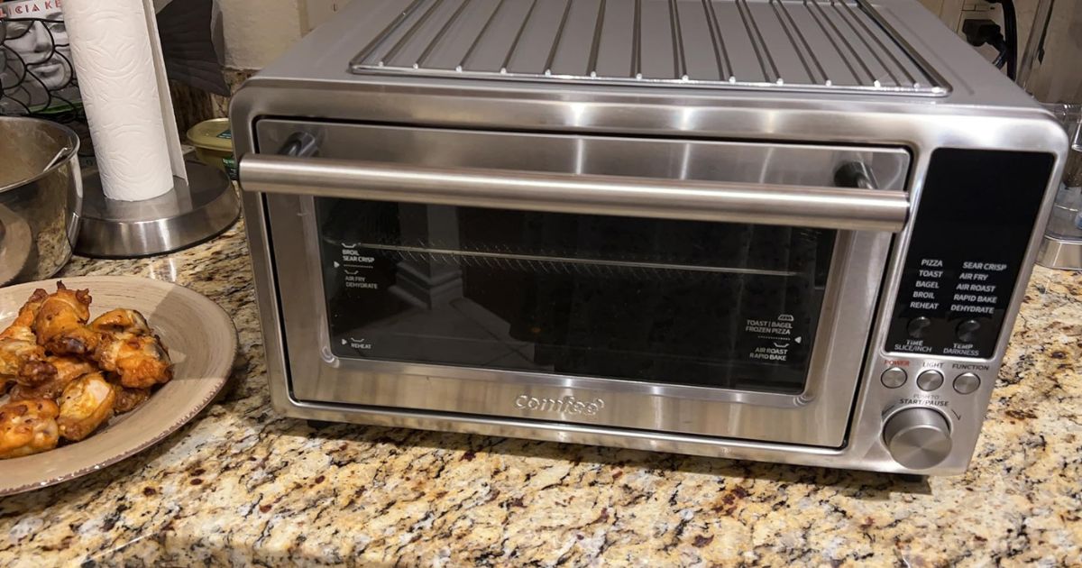 Comfee' Air Fryer Oven on a counter next to a plate of chicken wings