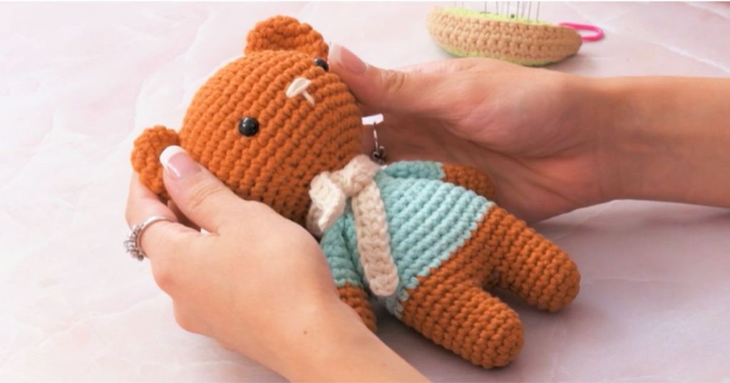 Hand holding a handmade crocheted bear