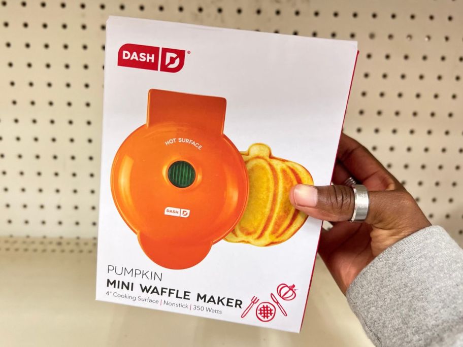 A hand holding a Dash Mini Wafflemaker Pumpkin