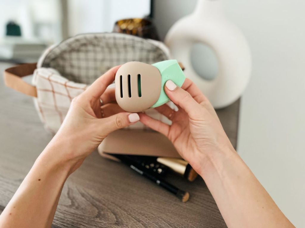 Hand putting a sponge into a holder