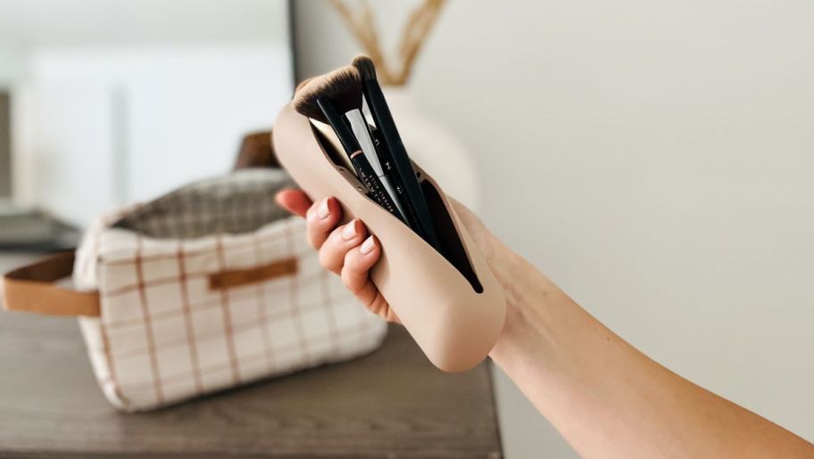 Hand holding a brush holder