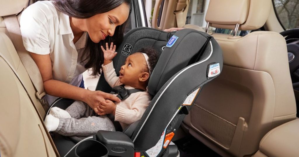 Woman buckling a baby into a carseat