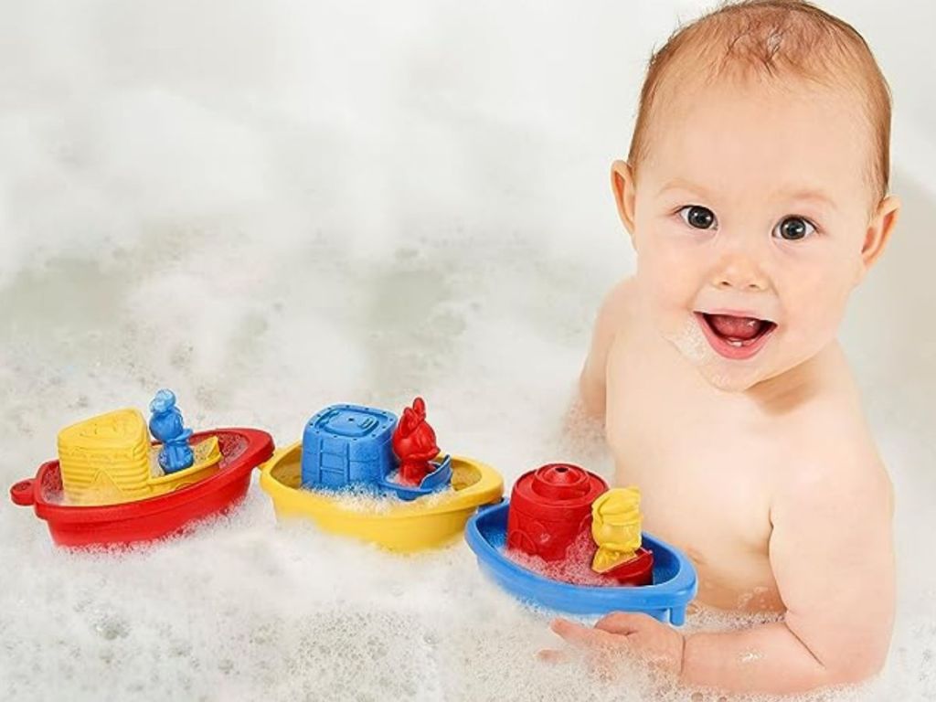 Baby in tub playing with Green Toys Mickey Linking Boats