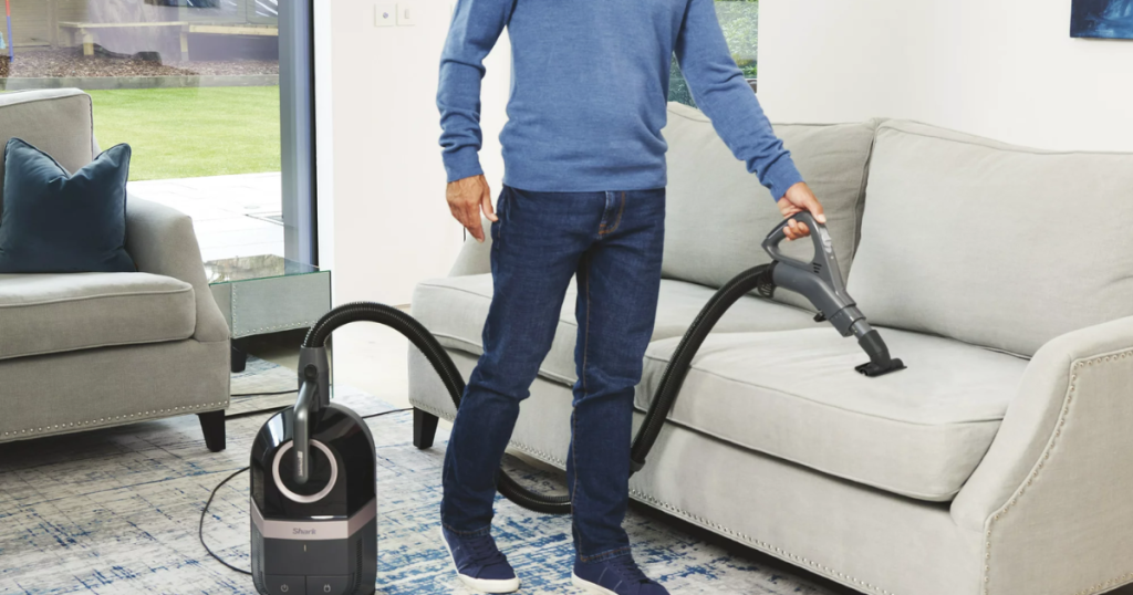 Person vacuuming their living room with a Shark Bagless Corded Canister Vacuum