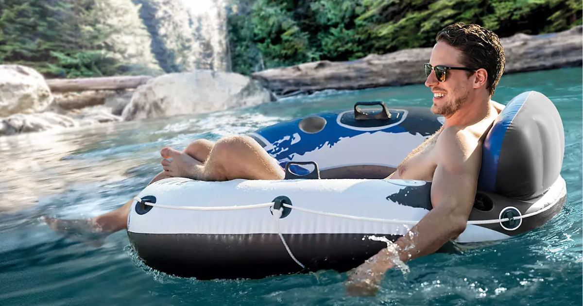 man in a blue, black and white float ton a river