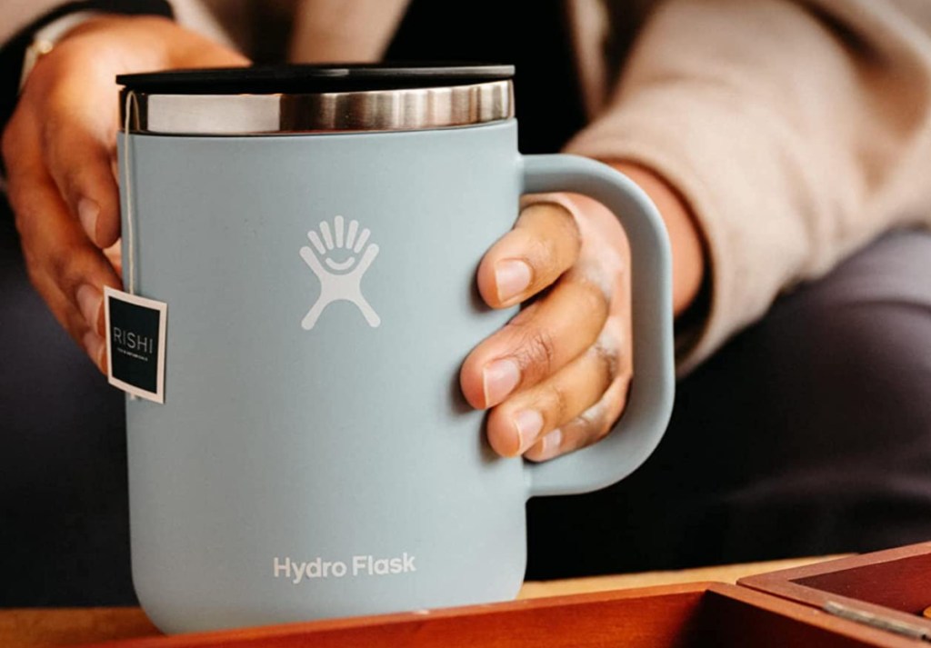 Hand holding a stainless steel Hydro Flask Mug from Amazon