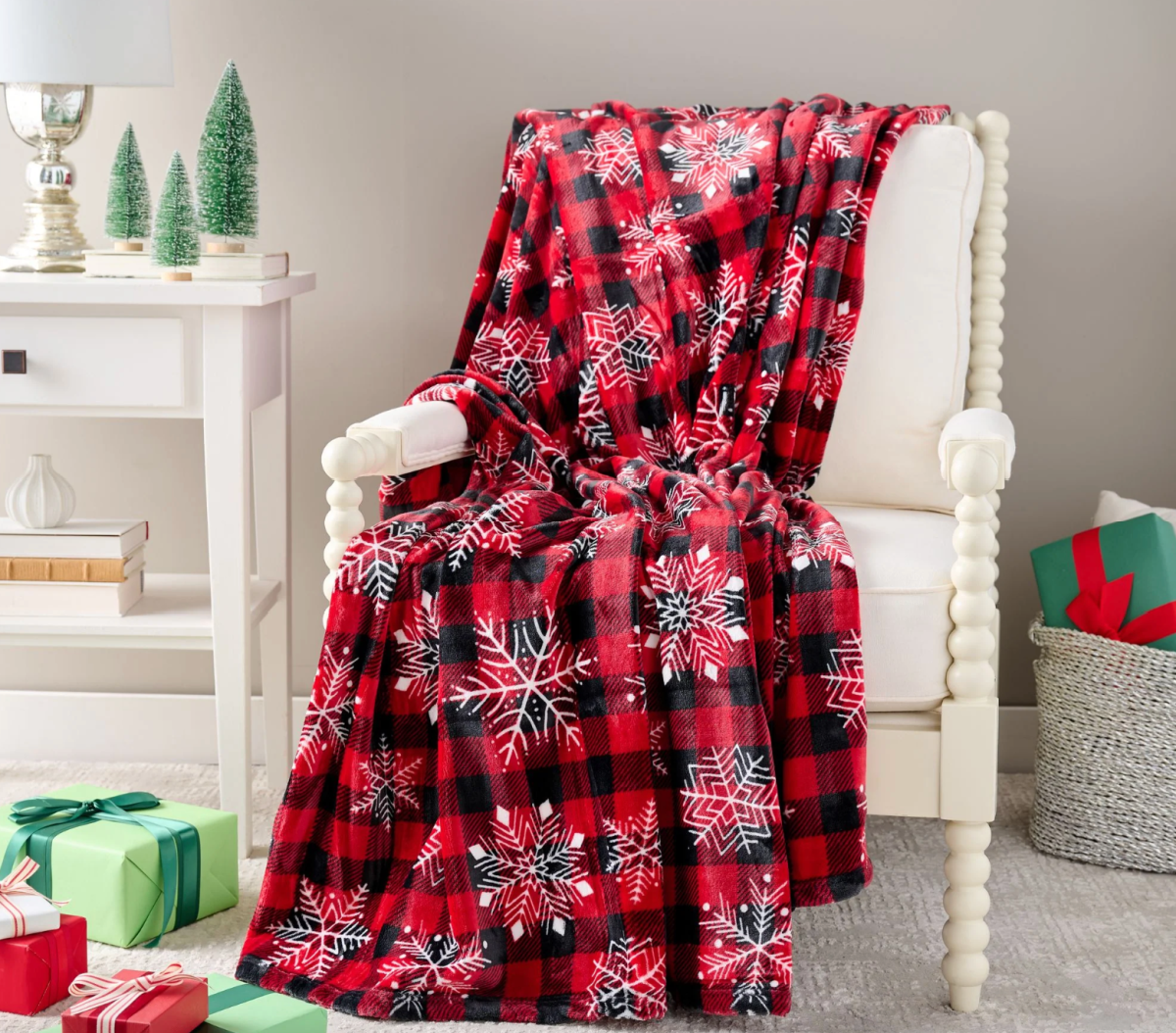 A Kringle Express Nostalgic Throw Blanket draped over a chair that you can buy at a discount with a QVC promo code for 2023
