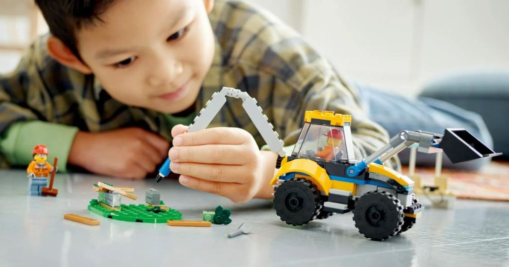 A child playing with a LEGO digger
