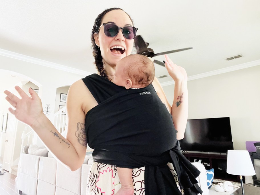 woman with baby in black carrier sling on her chest