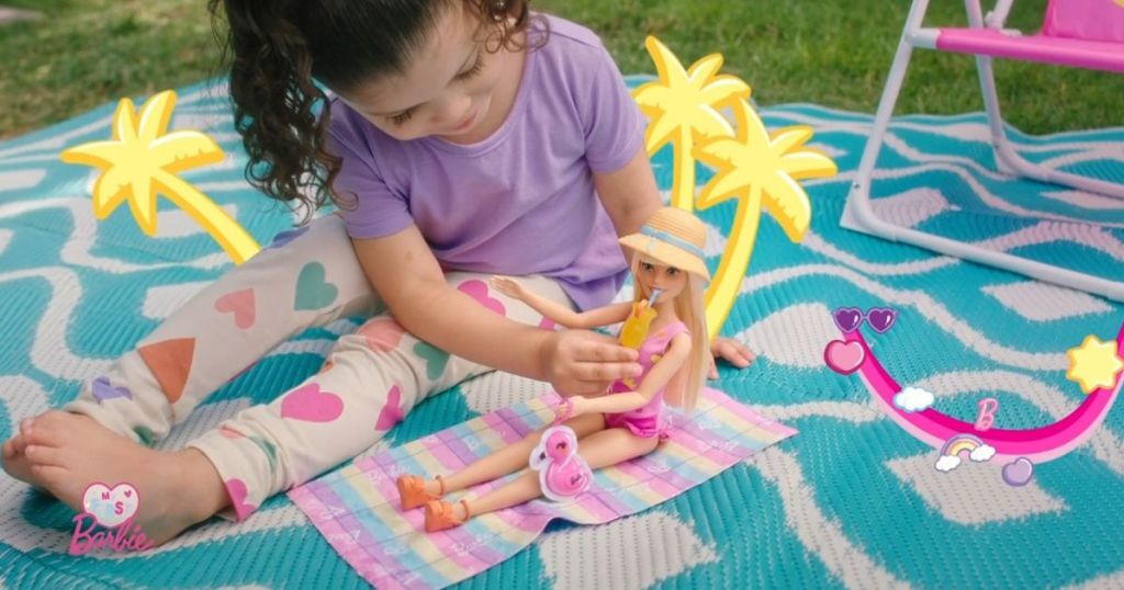 Girl playing with a Barbie playset