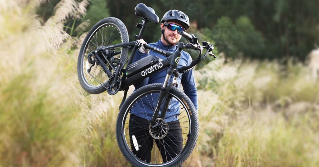 man carrying black bike