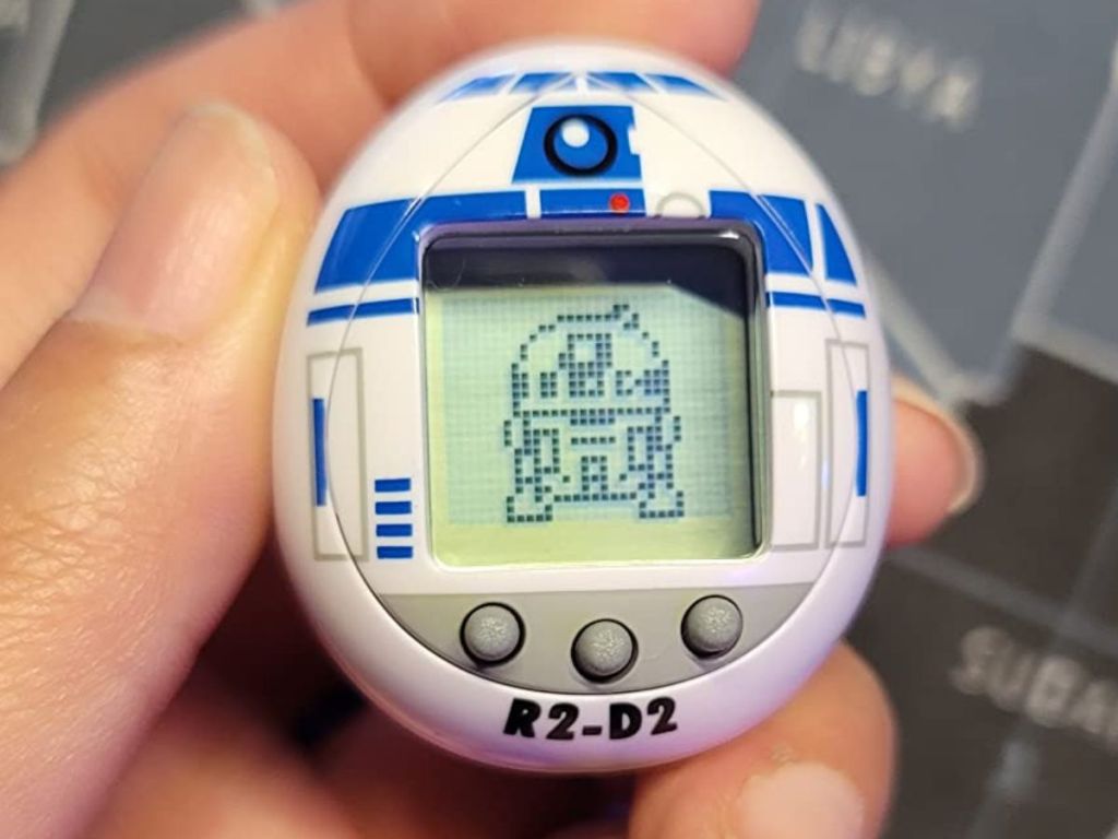 Hand Holding an R2-D2 tamogatchi Toy