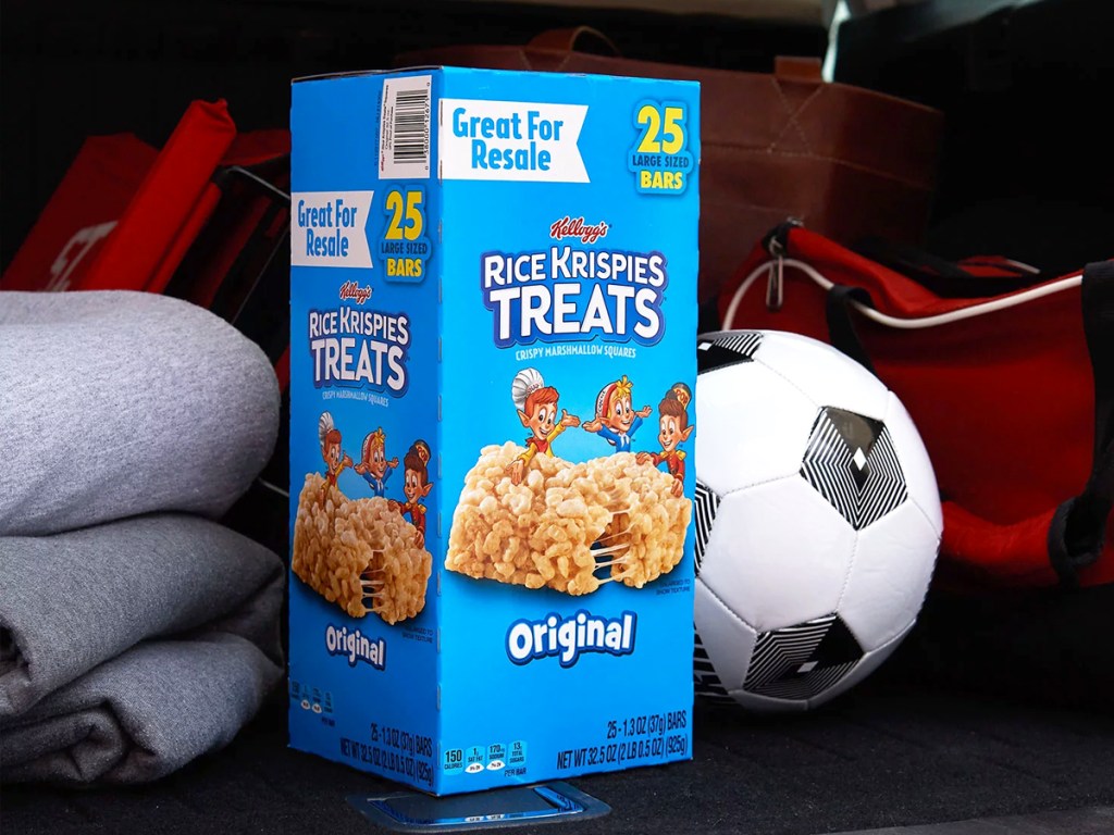 large box of Rice Krispies Treats in back of car near a soccer ball