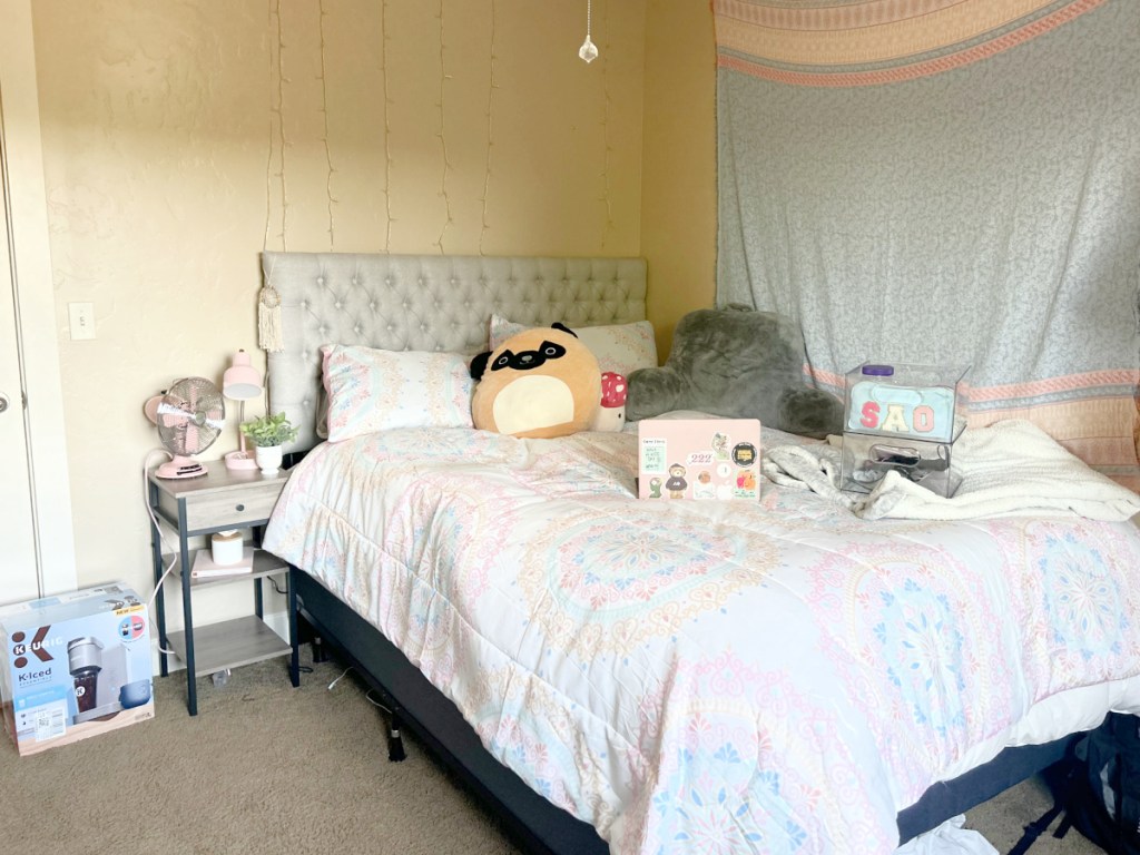 college room with pink bedspread and gray bedrest pillow
