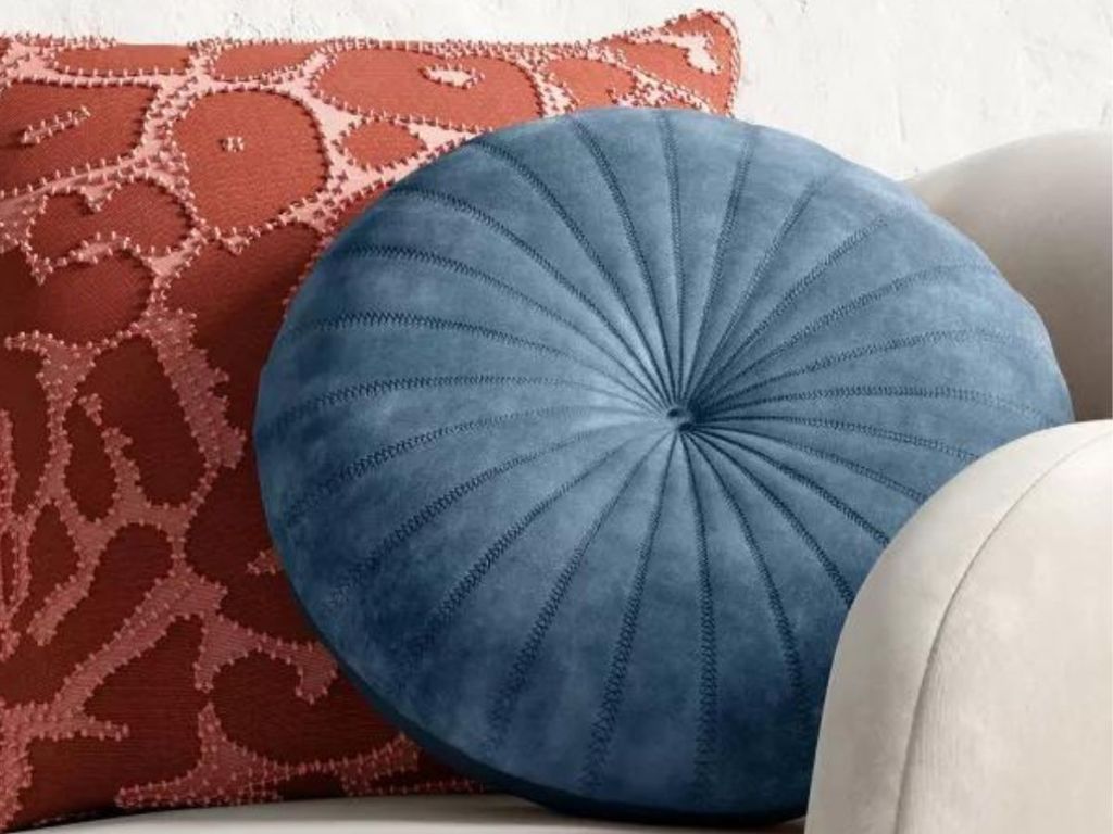 Round Throw Pillow on a chair with a square throw pillow
