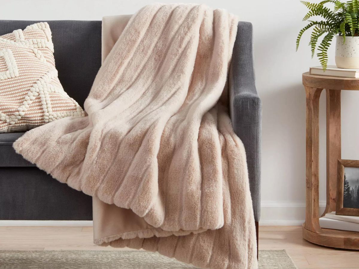 A textured faux fur blanket on a gray couch 