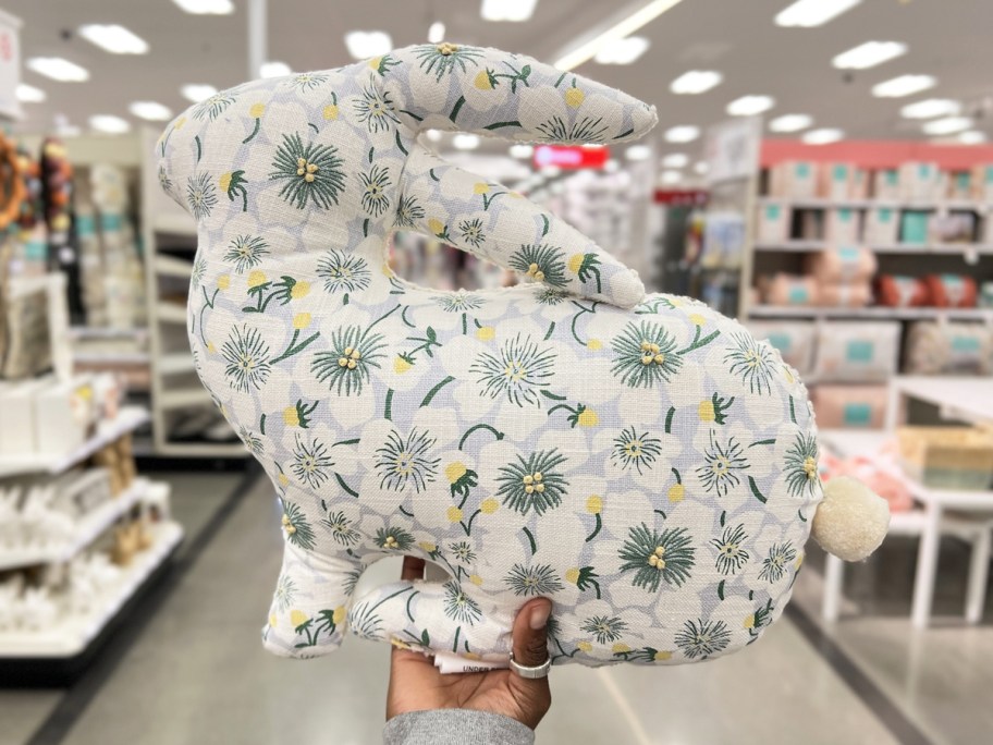 hand holding up a floral print bunny-shaped throw pillow