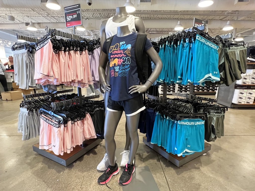 mannequins wearing under armour clothing with racks of shorts on either side of them