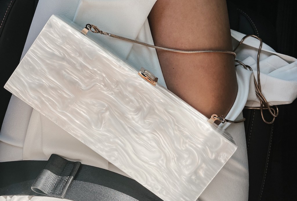 white acrylic purse on lap in car