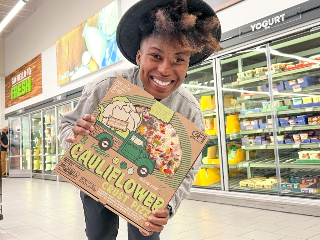 woman holding boxed veggie pizza
