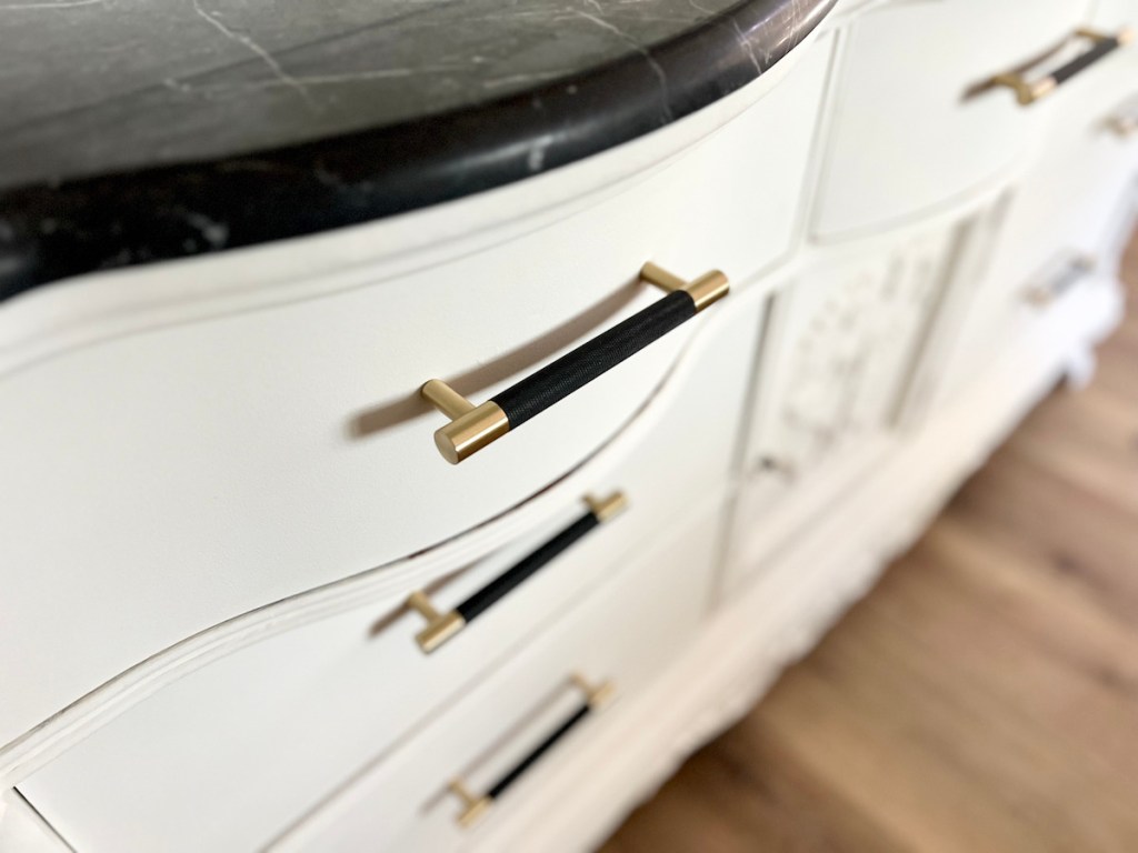 close up of black and white dresser with knobs