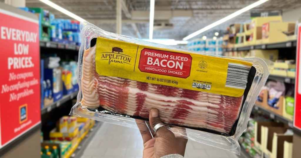 holding a package of bacon