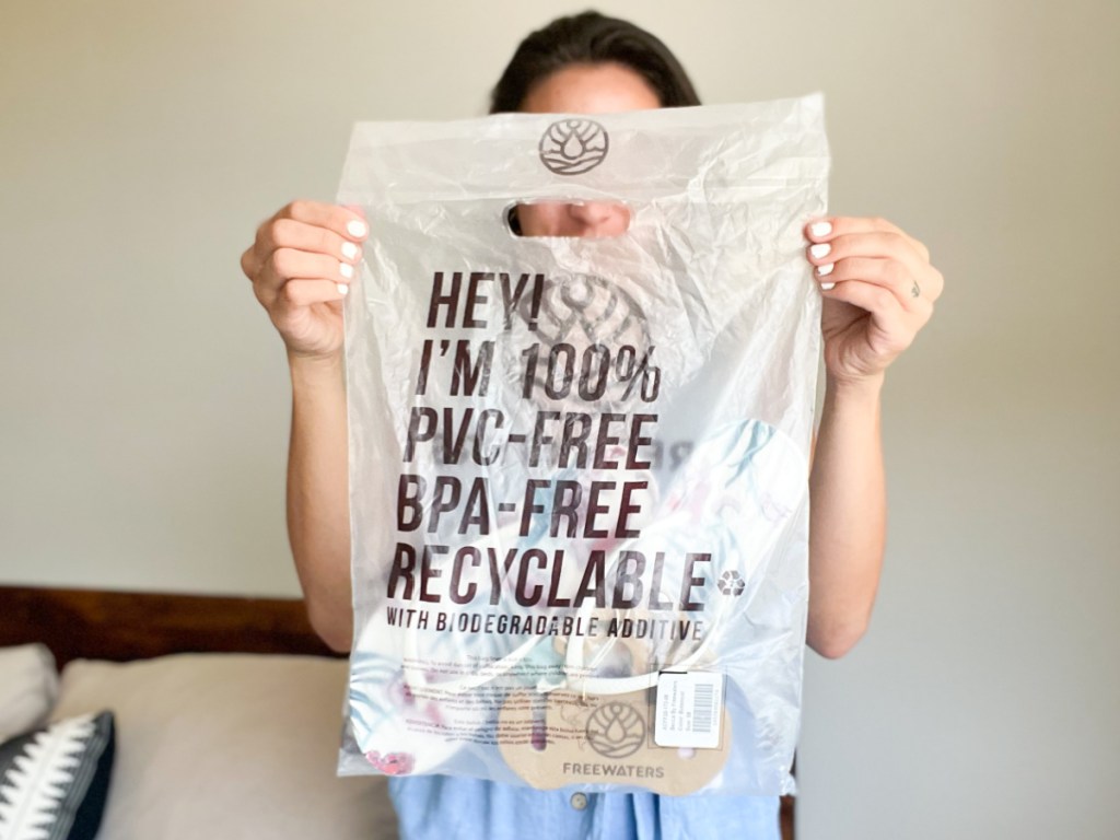 woman holding recyclable bag in front of face